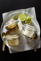 different types of sauces in glass jars. with pistachios, cashews and vegan mayo.