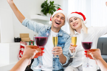 A happy family with a child is celebrating Christmas with their friends on video call using webcam. Family greeting their relatives on Christmas eve online. New normal virtual event