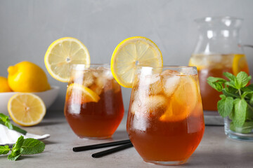 Delicious iced tea with lemon on grey table