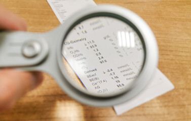 Printed Results of arterial blood gas analysis viewed under magnifying glass.
