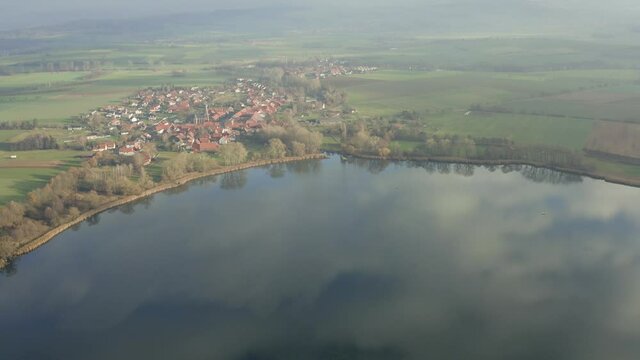 Drone aerial of the typical german village Seeburg located at the Seeburger See on a beautiful Sunday morning. A scenic winter and autumn landscape inviting for a hike with the family in Germany.