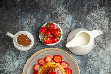 top view yummy pancakes with strawberries and honey on a light background sweet fruit cake