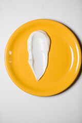 White cream on a yellow plate