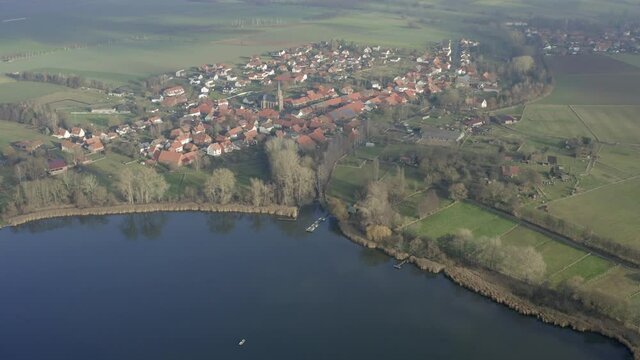 Drone aerial of the typical german village Seeburg located at the Seeburger See on a beautiful Sunday morning. A scenic winter and autumn landscape inviting for a hike with the family in Germany.
