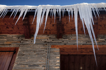 Horizontal low angle view of some icicles hanging from a house roof in Salardú, Vall d’Aran, Lleida, Spain 