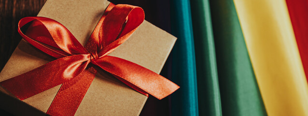 gift box with red bow for christmas new year on the background of the rainbow flag