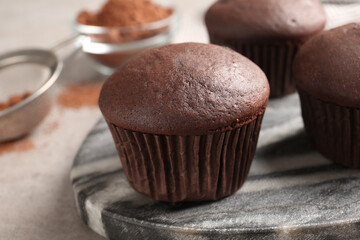 Delicious fresh chocolate cupcakes on grey marble board, closeup