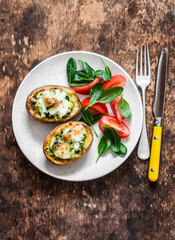 Roasted potatoes stuffed spinach and mozzarella on a wooden background, top view. Delicious tapas, snack, appetizers