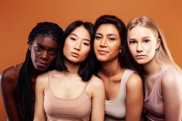 Obraz premium young pretty asian, caucasian, afro woman posing cheerful together on brown background, lifestyle diverse nationality people concept
