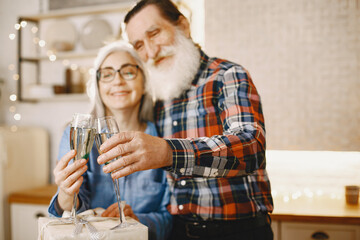 Age and people concept . Senior couple at home. People with champagne.
