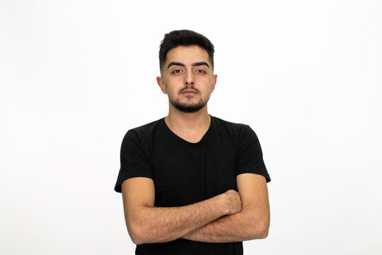 Young male model posing at studio. He is wearing a black shirt. Isolated image and white background.