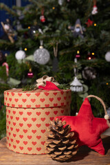 Craft round gift box next to decorated Christmas tree