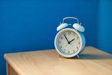 Alarm clock in a room, blue wall corner