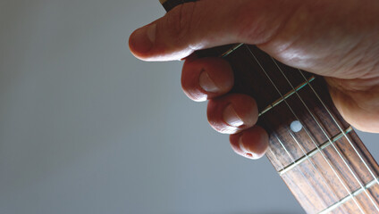 hand holding neck of guitar