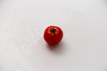 Cherry tomato covered with splashing water. White background. Isolate.