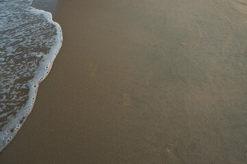 Clear sea water, wave and sand beach. Text space.