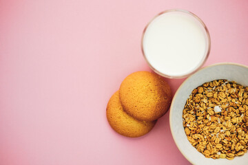 cookies milk muesli on a pink background. top view