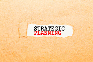 text STRATEGIC PLANNING on a torn piece of paper, business concept