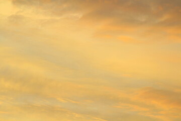 Obraz premium Sun below the horizon and clouds in the fiery dramatic orange sky at sunset or dawn backlit by the sun. Place for text and design