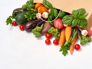 Vegetables in paper bag on white background.