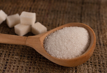 Fototapeta na wymiar Pieces of lump sugar on burlap. granulated sugar close-up. Refined sugar. Sugar