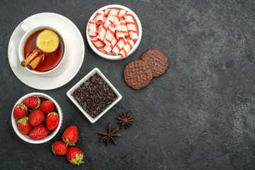 top view fresh strawberries with sweets and tea on dark background photo sweet cracker