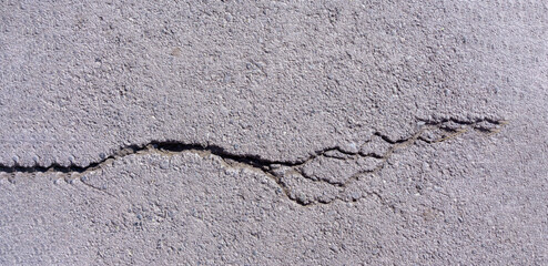 cracks in the asphalt. resolution old concrete cement with cracks and natural destruction from time and weather conditions. banner