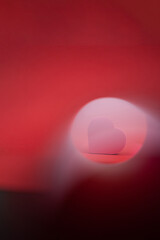 Red heart on red background with light effects