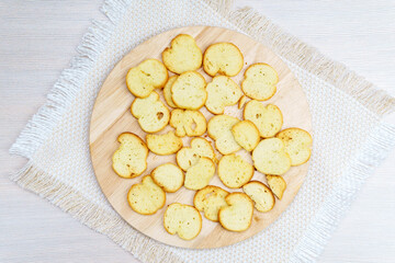 homemade croutons from white bread on a wooden board top view