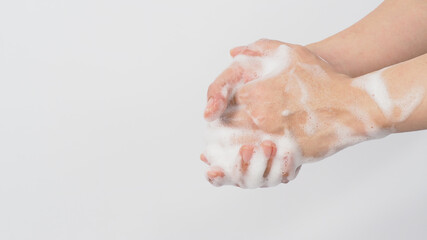 Fototapeta premium Hand wash gesture with foaming hand soap on white background.copy space