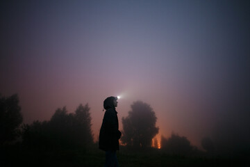 Girl at night in the fog.