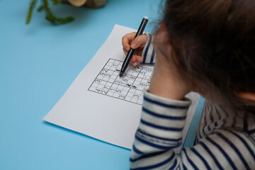 Child solves Japanese crossword sudoku