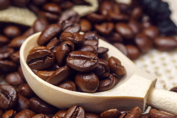 ragrant coffee beans close-up. wooden spoon takes coffee beans