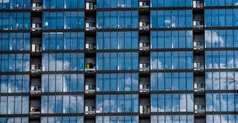 Obraz premium Skyscraper windows with reflected blue sky and clouds