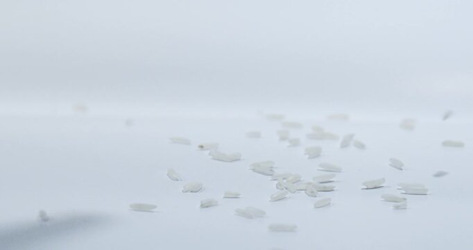 Rice falling in Slow Motion onto a white surface. Isolated on white. 120 FPS.