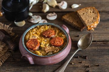 Christmas cabbage soup in ceramic bowl on natural wooden background.