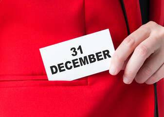 Text December 31 on the card in the hands of a businessman, a close-up of the jacket.