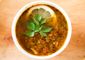 Soup with lemon slice top view.