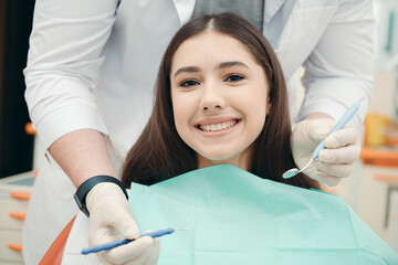 Portrait of a brunette in the dentist's office during the examination. Healthy teeth