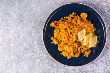 Freshly cooked seafood paella on a blue plate