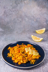 Freshly cooked seafood paella on a blue plate