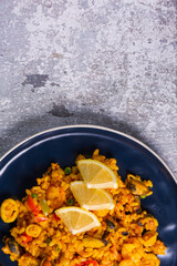 Freshly cooked seafood paella on a blue plate