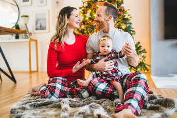 Christmas family with baby close to a tree