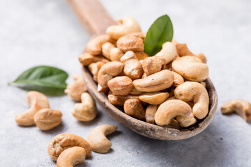 Cashew nuts in spoon top view. Healthy raw nuts of cashew fruit. Tasty cashew nuts. The cashew tree is a tropical evergreen tree that produces the cashew seed and the cashew apple.