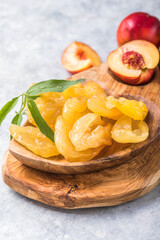 Dried fruits or candied and Fresh peaches with leaves on stone background