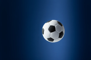 Traditional soccer ball flying over blue background.
