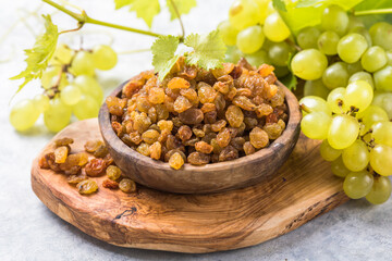 Golden raisins  in bowl on stone background, table top view. Dried fruit, healthy snack food