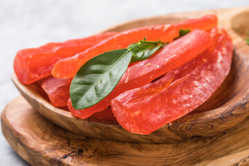 candied fruit, dried papaya with sugar in bowl on wooden table background.