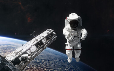 Naklejka premium Astronaut, space station orbiting planet Earth. Science fiction. Elements of this image furnished by NASA