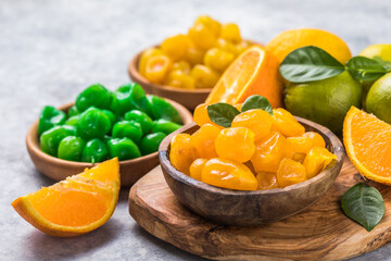 Variety Сandied fruit, dried kumquat  with orange, lime, lemon  flavor in bowl on stone table background.